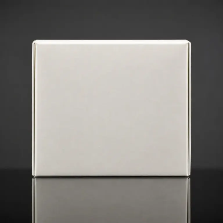 Blank off-white matte paper packaging box reflected sharply on glossy black acrylic in a minimal studio