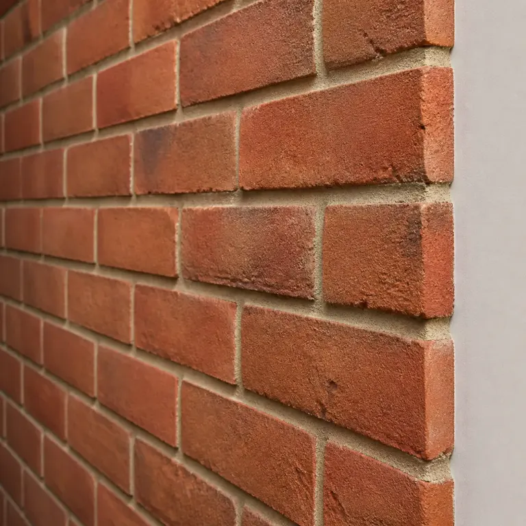 Red brick wall with repeating mortar joints, shallow focus, and a finished edge