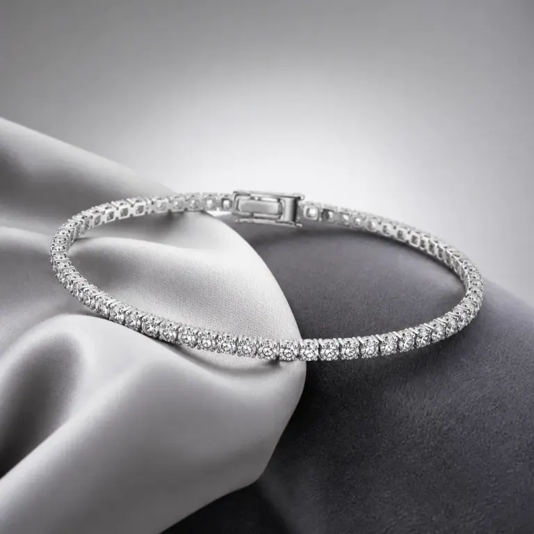 Backlit tennis bracelet with clear gemstones arranged over silver silk on a gray gradient background