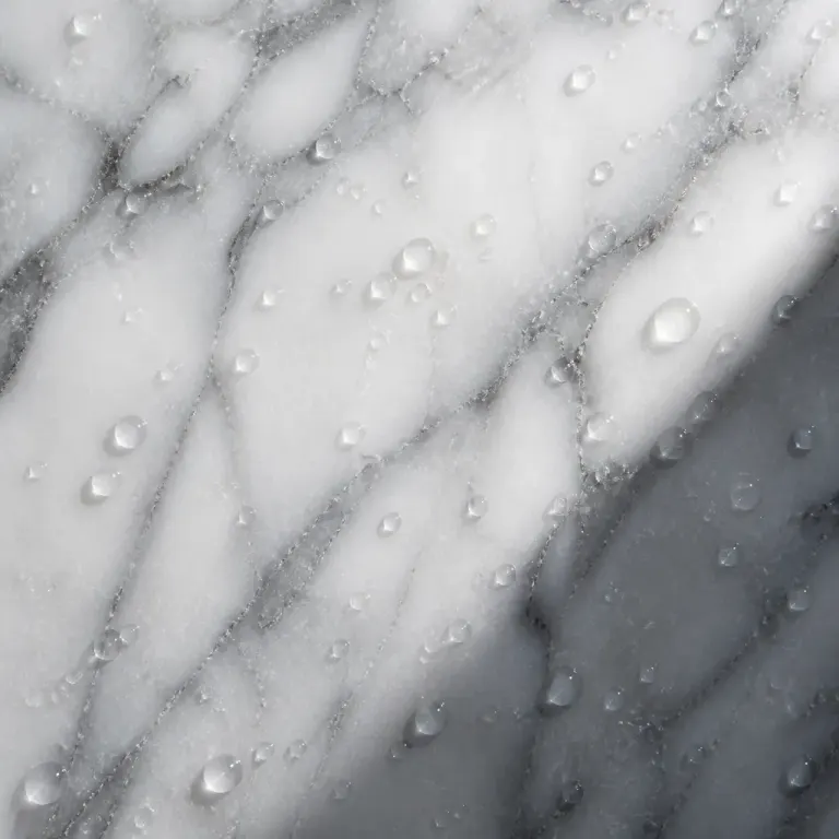 Backlit white marble with flowing grey veins, water droplets, and a soft diagonal shadow
